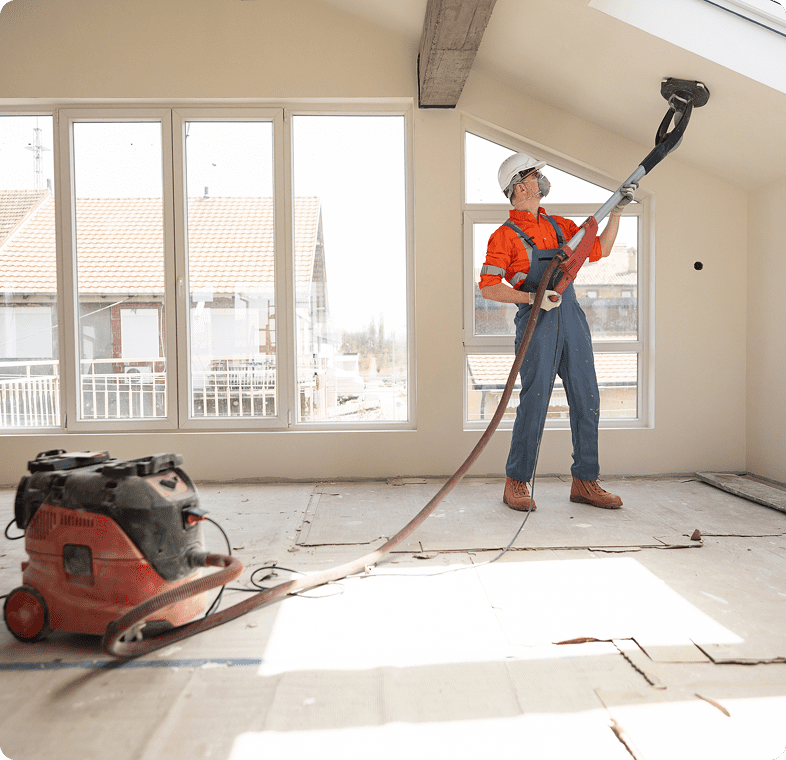 Man using sander in unfinished room
